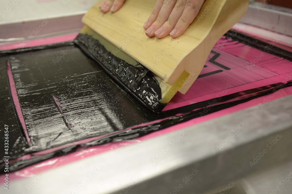 Screen printing, or silk screening, with black plastisol on t-shirts and posters.